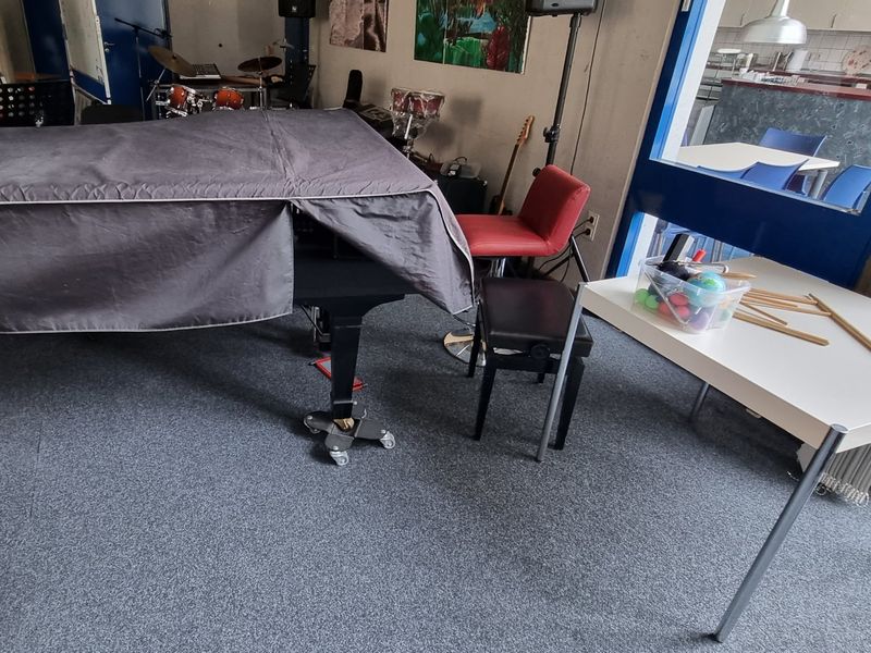 Flügel mit Transportrollen unter den Beinen im Musikraum