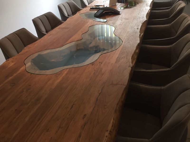 Aufgebauter Konferenztisch aus Massivholz mit Glaseinsätzen