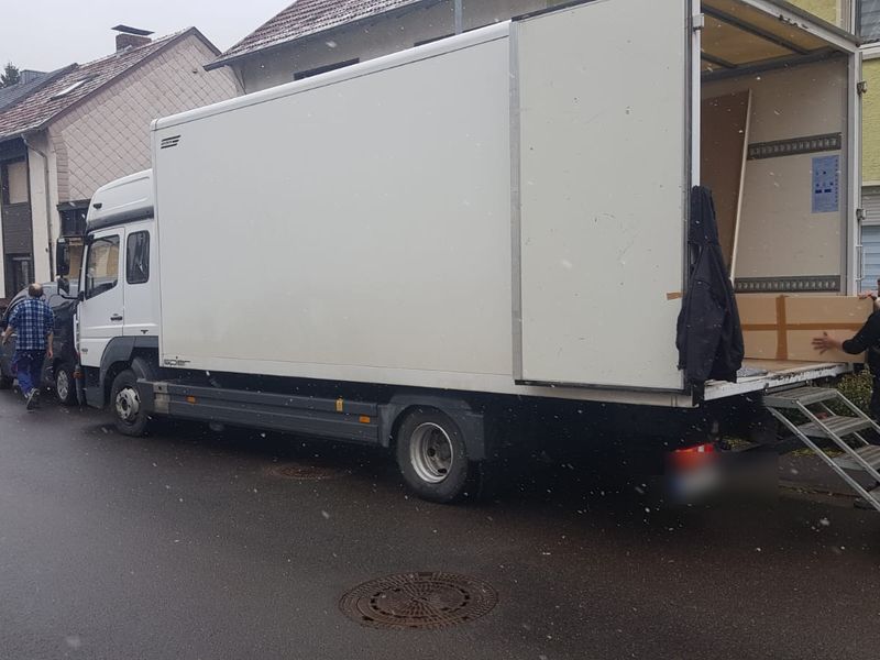 Umzugswagen mit ausgeklappter Laderampe beim Beladen