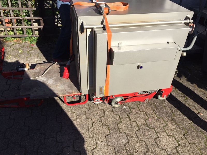 Schwerer Industrieofen auf Schwerlastrollern, mit Spanngurt gesichert