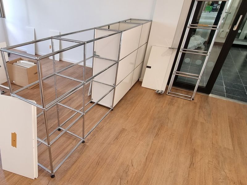 Aufbau eines weißen Büroregalsystems mit Chromrahmen
