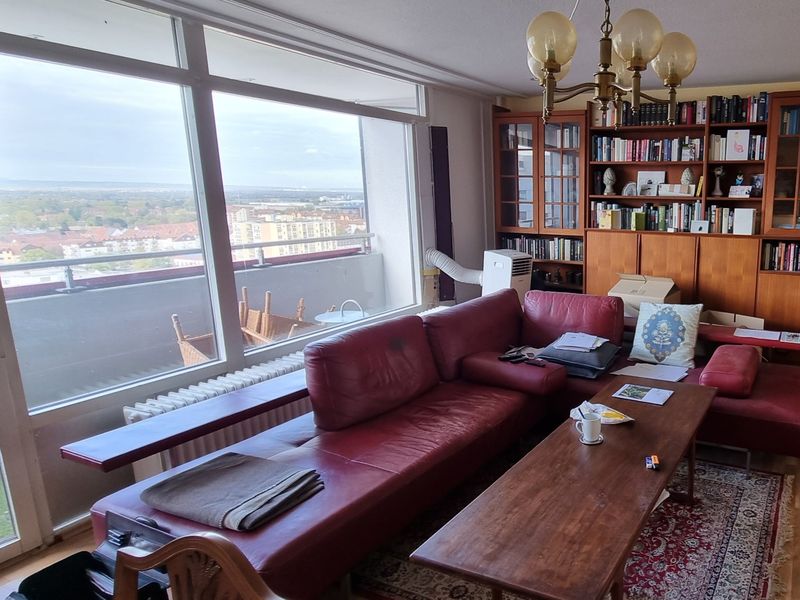 Eingerichtetes Wohnzimmer mit Bücherwand und Ledersofa vor dem Umzug